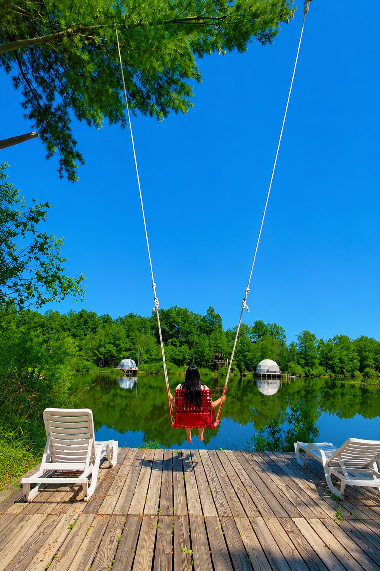 Guest enjoying a rope swing over the lake dock
