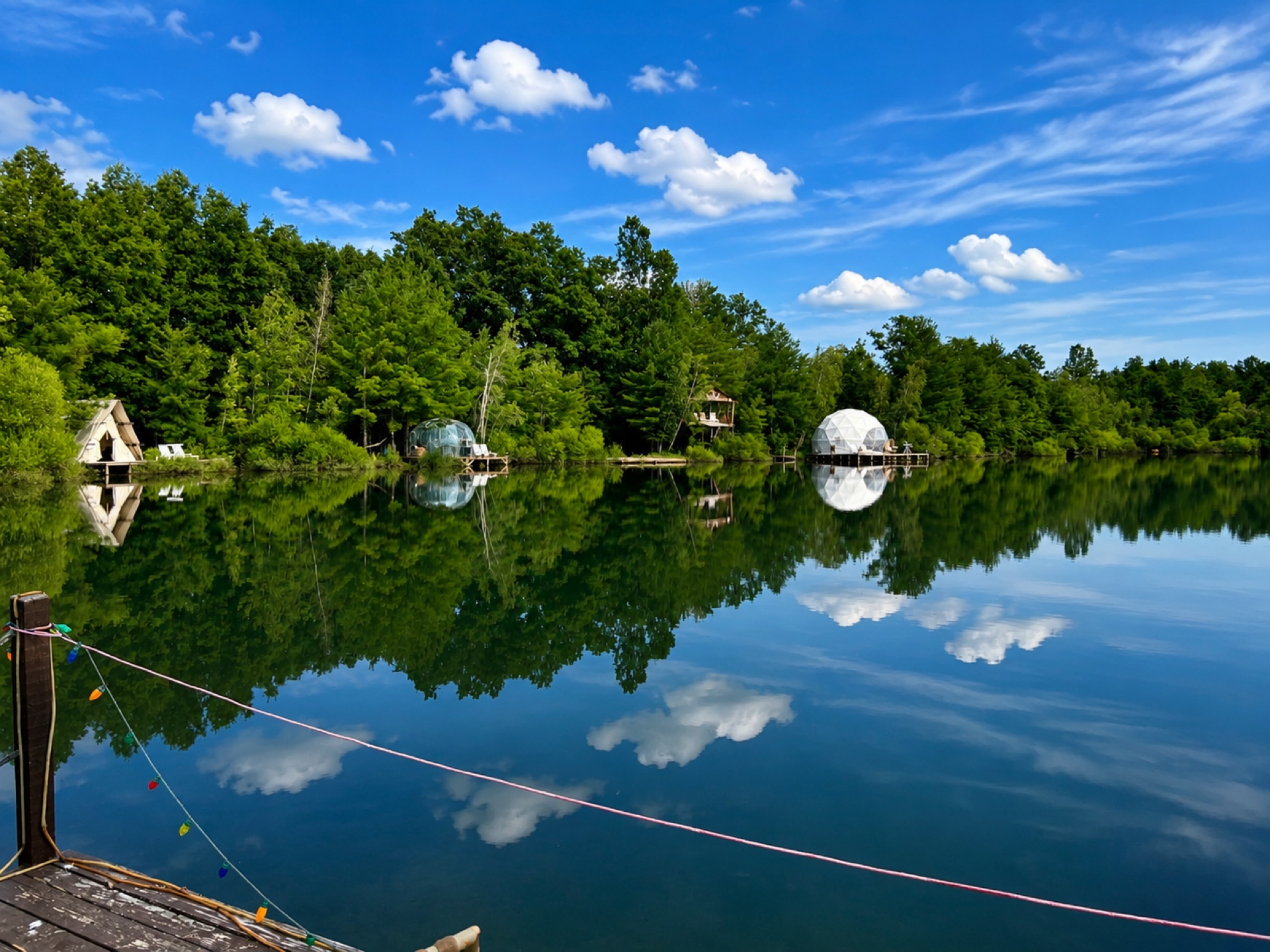 Panoramic view of glamping domes and tents on the lake