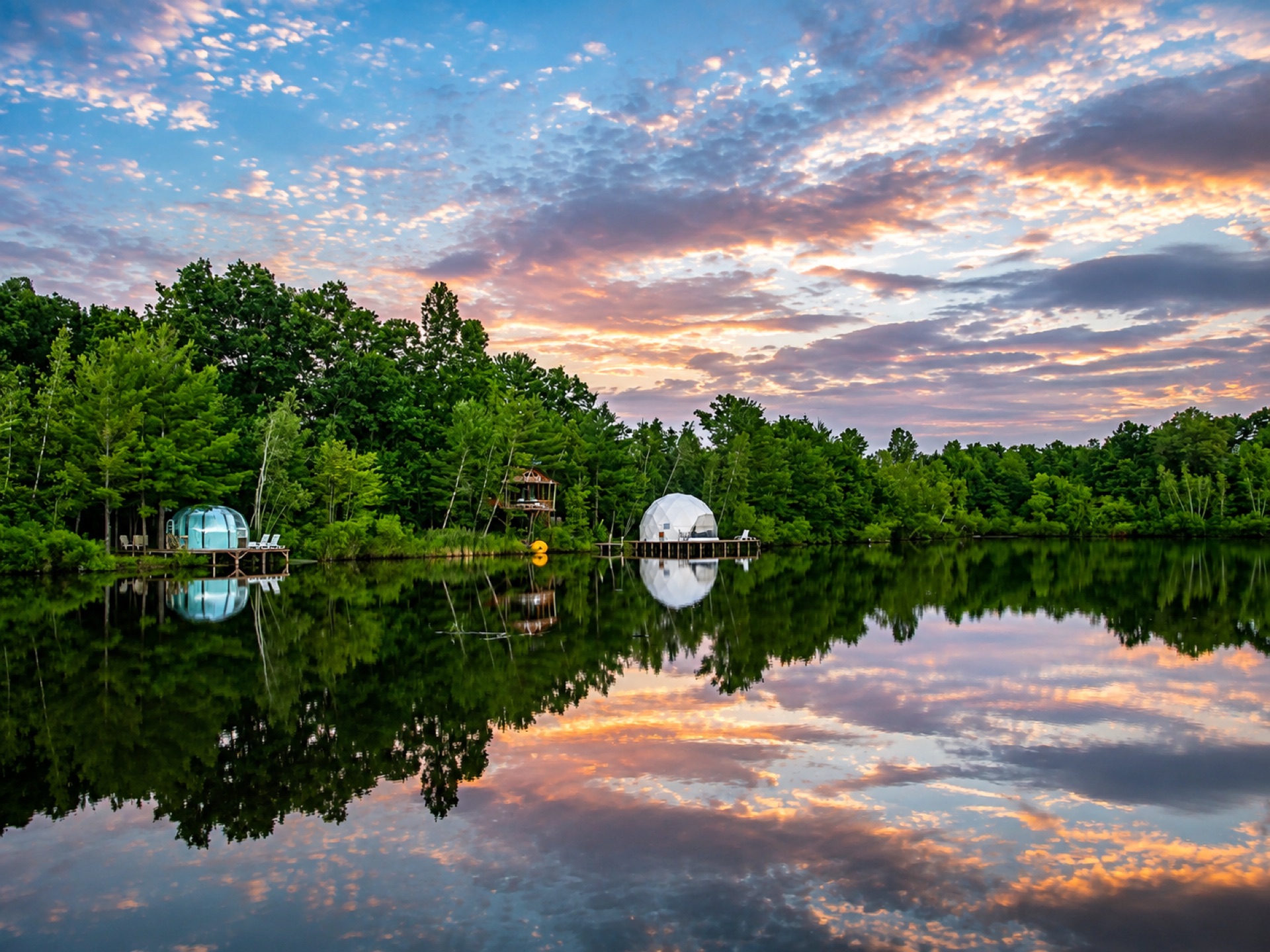 Sunset over the lake at 9 Lake Resort with glamping domes reflected in the water